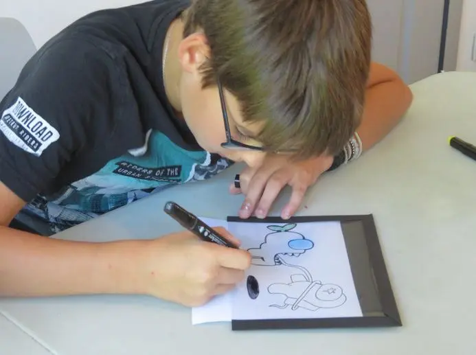 Garçon dessinant pendant un atelier créatif