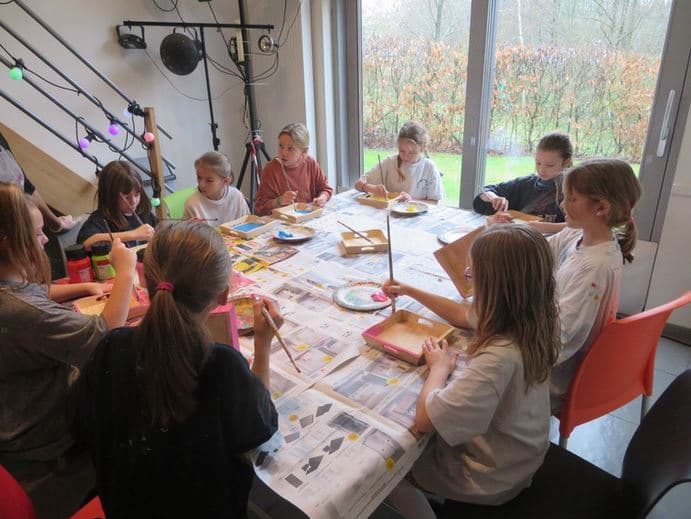 Enfants réunis autour d'une table pour un bricolage d'anniversaire