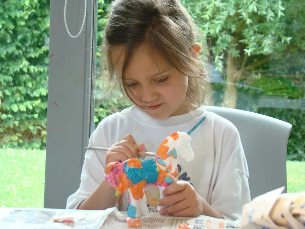 Petite fille concentrée réalisant une activité créative en extérieur