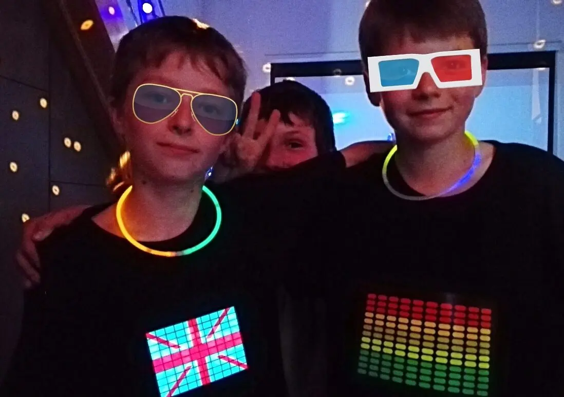 Garçons portant des lunettes fluo pendant la fête